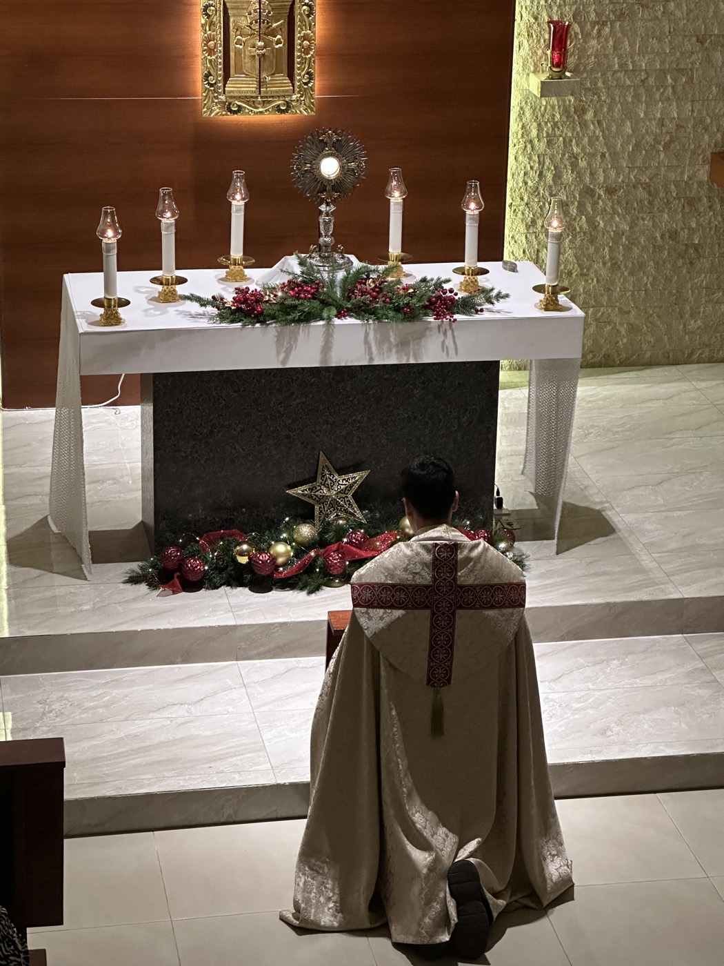 Sacerdote arrodillado frente al altar